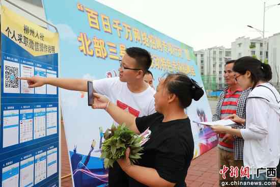在“云”雇用会现场,融康社区搬家贫困户伍世英(左二)正在咨询求职信息。刘梁春 摄 广西融安“云”雇用提供6000多个就业岗亭