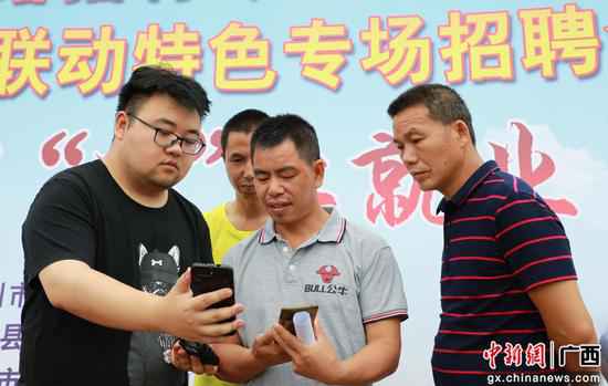 事恋人员正向易地搬家贫困户讲授企业和岗亭信息。肖婉莎 摄 广西融安“云”雇用提供6000多个就业岗亭