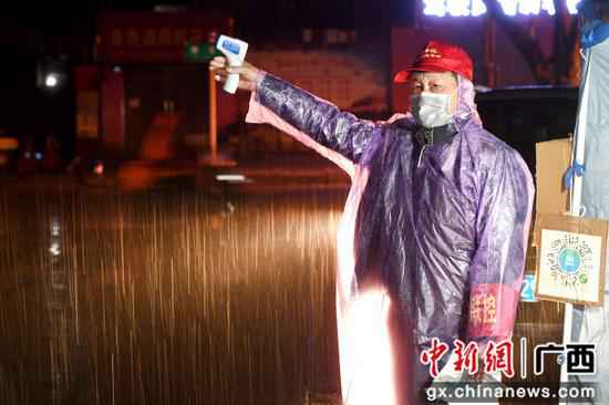 廖诗祥冒雨在小区疫情防控监测点站岗。 抗疫“最美家庭”柳州市4个家庭获全国、自治区表扬