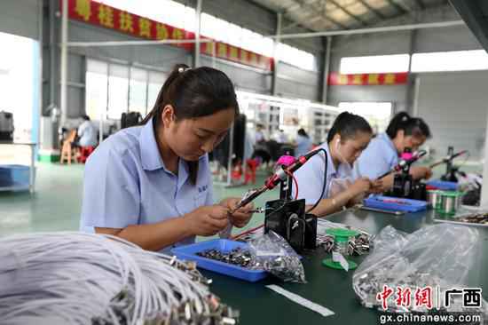 工人们在一家电子产物加工出产线上劳作。覃庆和 摄 广西融安:实现不变就业 固定脱贫成就