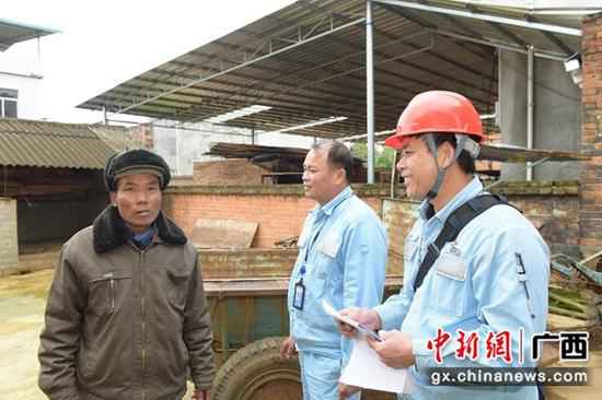 吴盈昌向低保户宣传优惠用电政策。易欢 摄 吴盈昌:始终惦念着老家这片热土