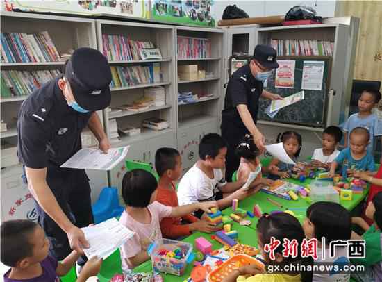 图为民警们正在发放校园安详宣传资料。李欣蓉摄 崇左领土警方开展“关爱留守儿童、共筑平安领土”主题勾当