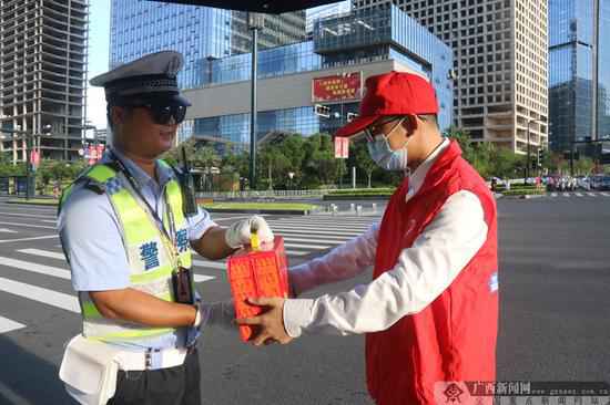 “红马甲”青年志愿者为交警同志送凉茶。通讯员 林慧霞 摄 助力创城:南宁青年志愿者开展系列志愿勾当