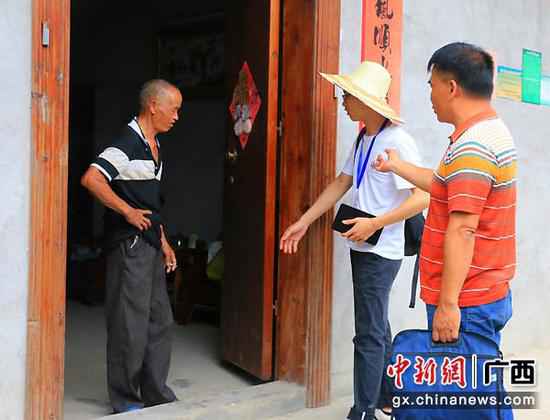 图为普查引导员廖健雄引导普查员入户开展脱贫攻坚普查事情。 金秀县头排镇完成国度脱贫攻坚普查挂号事情