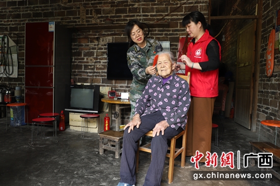 党员干部为方天社梳头 李晓锋 摄 河池金城江区百岁老人唱红歌 忆苦思甜感党恩