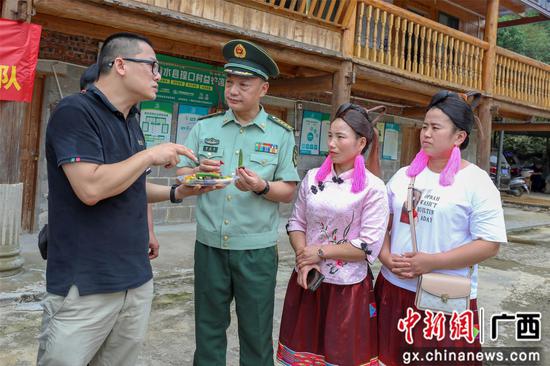 广西农科院工程师讲解果蔬贮藏与加工技术。李灿明 摄 武警柳州支队官兵“六一”送红瑶群众特色礼包