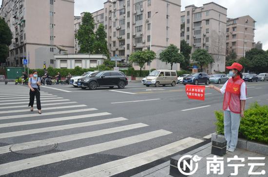 南宁:路口常驻“红马甲” 引领文明出行新风尚