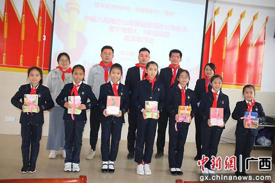 图为孩子们捧上心爱的书籍。罗先彬 摄 中建八局志愿者到南宁高山塘小学开展慰问助学